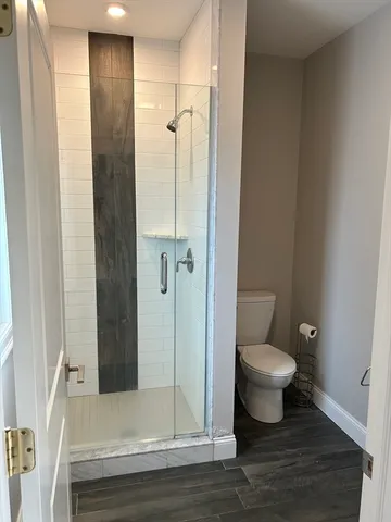 a bathroom with a granite countertop toilet a sink and a shower