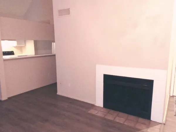 a view of empty room with wooden floor and fireplace