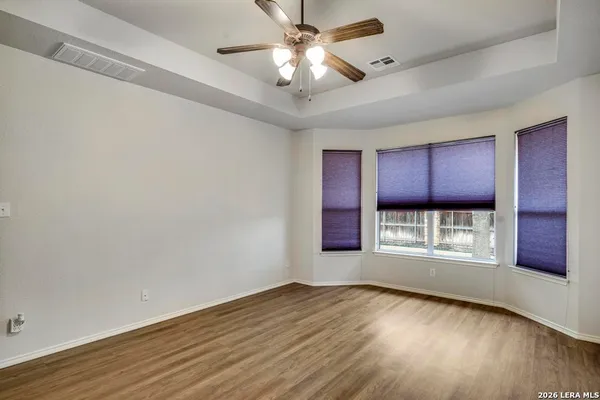 a view of an empty room with a window and wooden floor