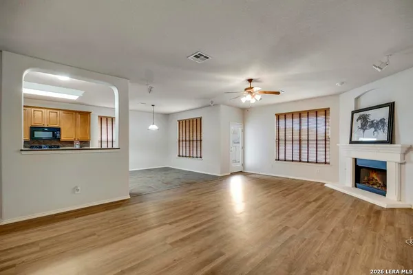 a view of an empty room with window and wooden floor
