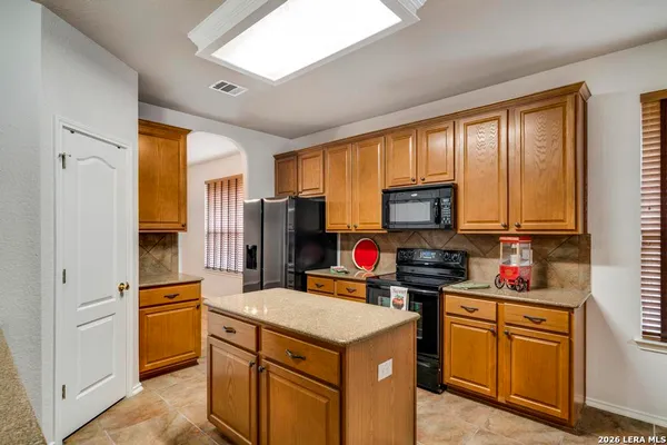 a kitchen with stainless steel appliances granite countertop a stove refrigerator sink and microwave