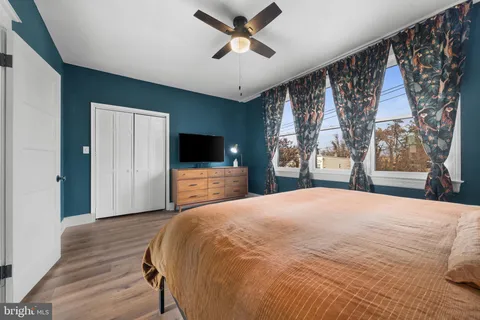 a hallway with wooden floor and a potted plant