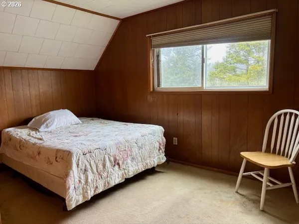 a bedroom with a bed chair and window