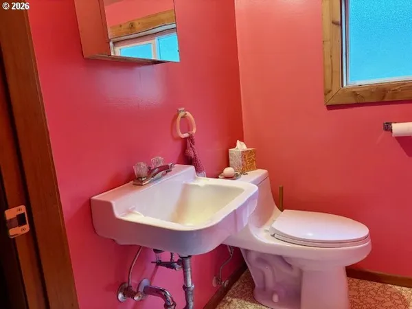 a bathroom with a sink a toilet and mirror