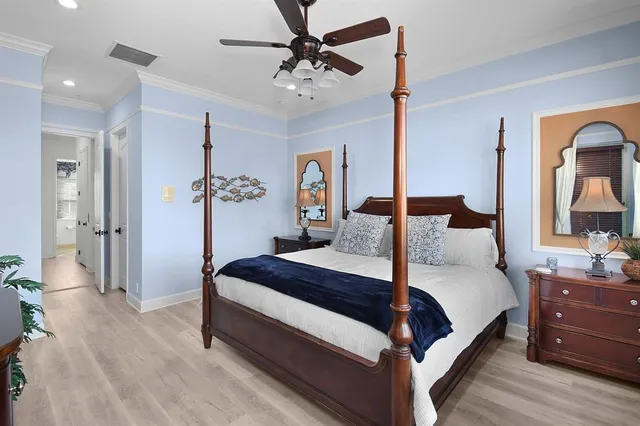 a bedroom with a large bed and a chandelier