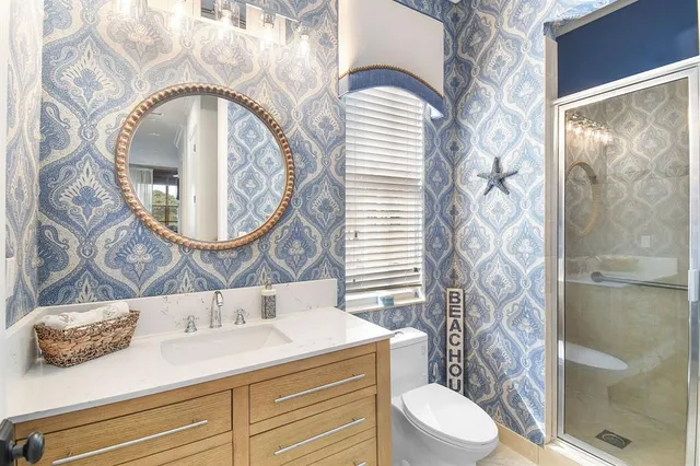 a bathroom with a granite countertop sink mirror vanity and toilet