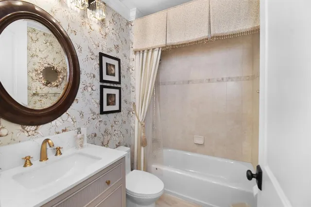 a bathroom with a bathtub sink mirror vanity and toilet