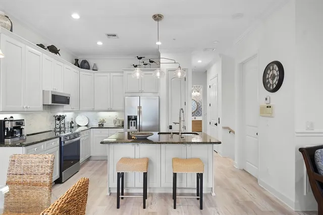 a kitchen with granite countertop a stove a sink and a refrigerator