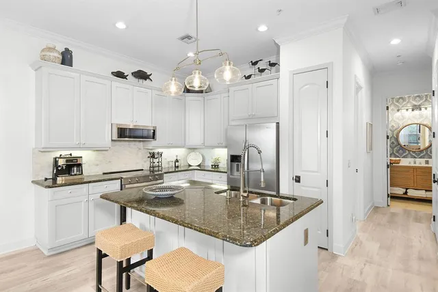 a kitchen with stainless steel appliances granite countertop a sink a stove and a refrigerator