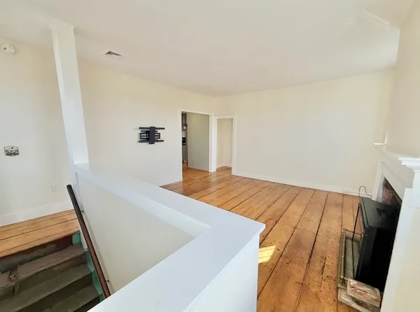 a view of an empty room and wooden floor