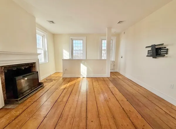 a view of wooden floor and a fireplace in a room
