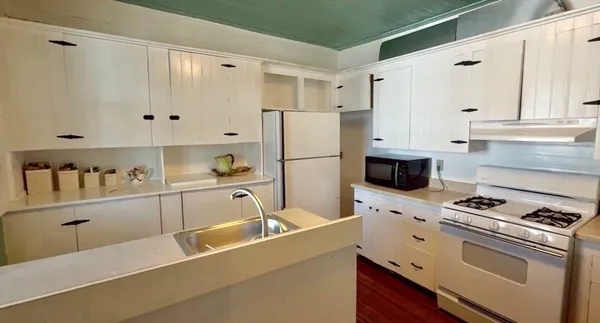 a kitchen with granite countertop a sink cabinets and stainless steel appliances