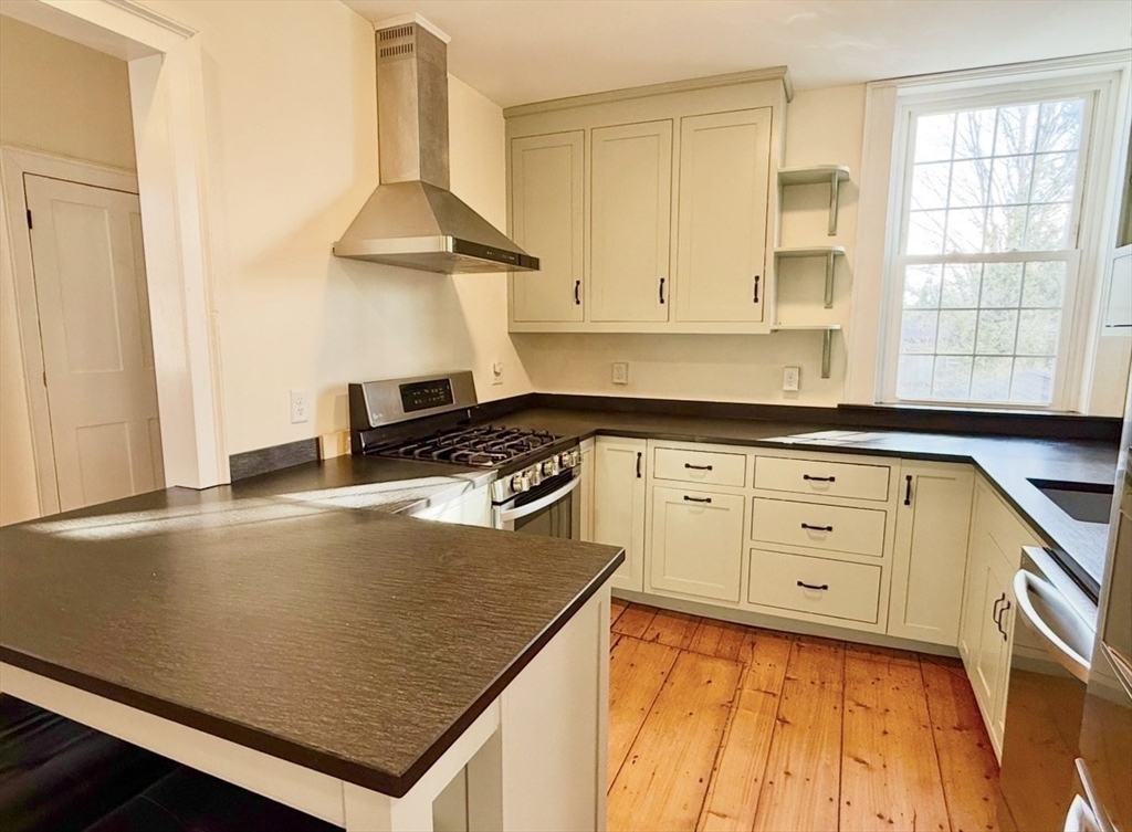 278 East Main Street Plainfield, MA 01070 - Photo 6 of 33 a kitchen with granite countertop a stove a sink and white cabinets with wooden floor