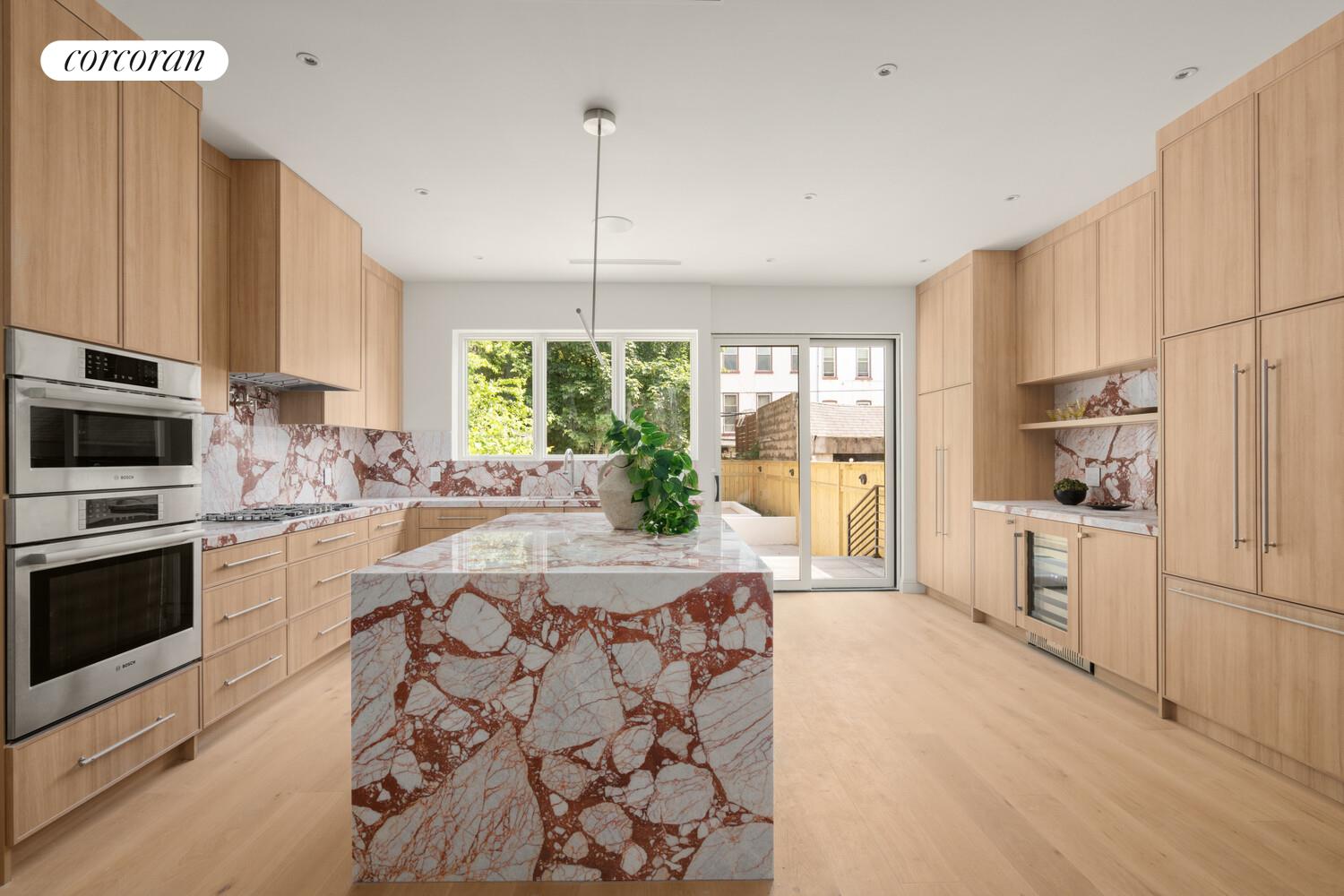 700 Monroe Street Brooklyn, NY 11221 - Photo 4 of 18 a large kitchen with kitchen island a large window a sink stainless steel appliances and cabinets
