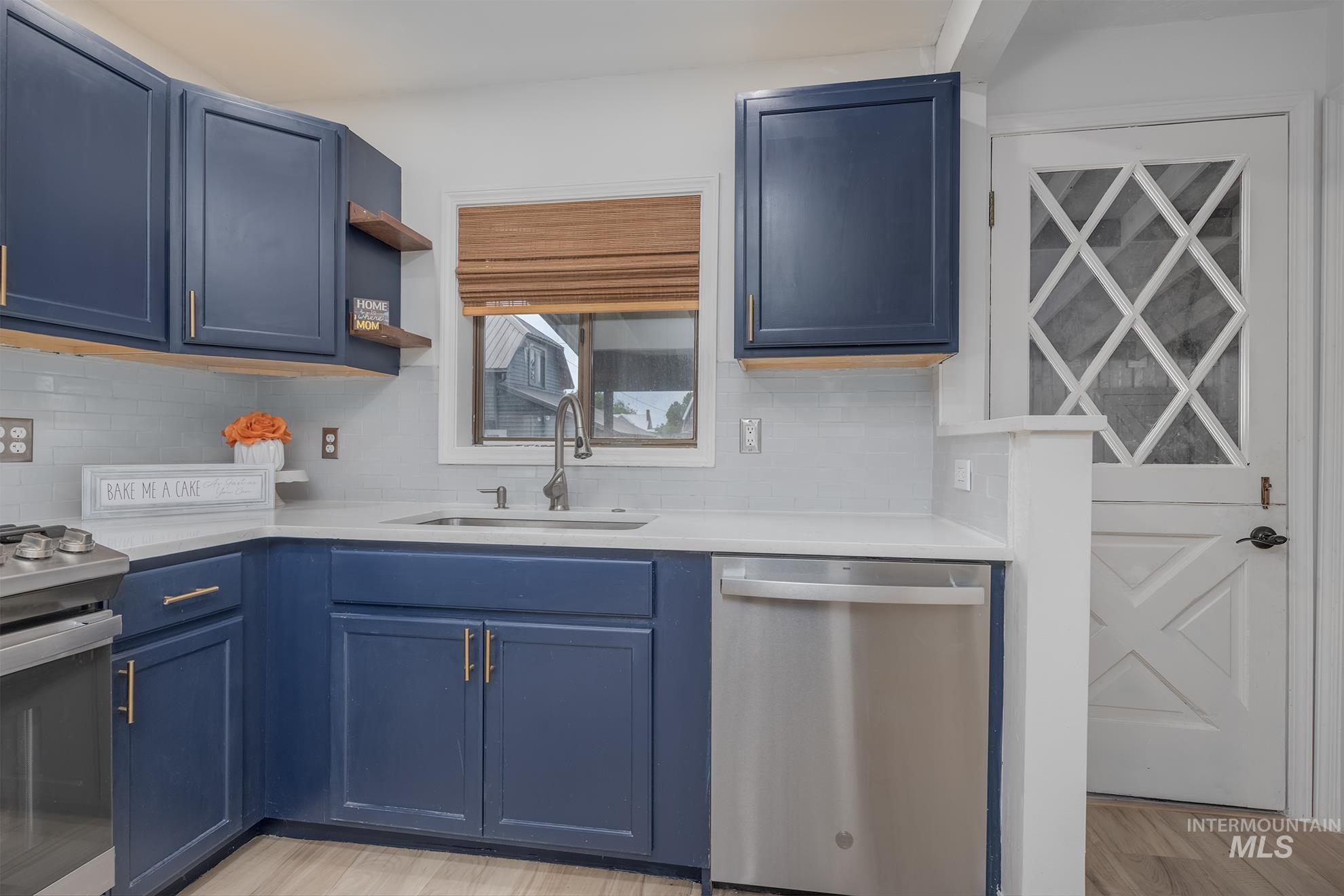 61 Southwest 4th Street Ontario, OR 97914 - Photo 11 of 42 Kitchen featuring blue cabinetry, light-colored countertops, subway tile backsplash, and stainless steel appliances