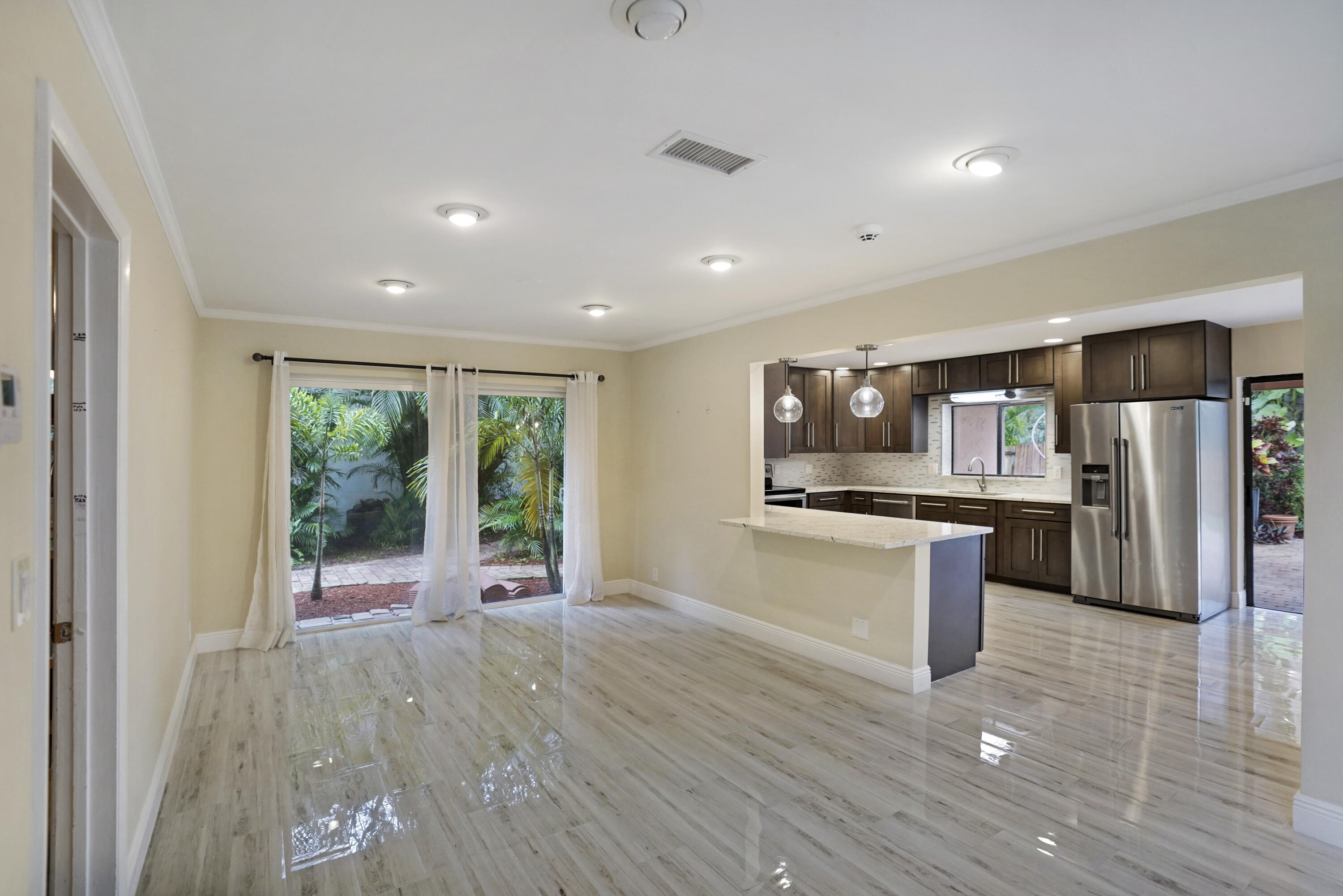 2674 Northwest 41st Street Boca Raton, FL 33434 - Photo 11 of 48 a kitchen with stainless steel appliances kitchen island granite countertop a refrigerator and a sink