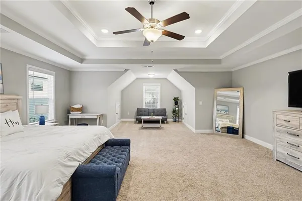 a bedroom with a bed a couch and a large window