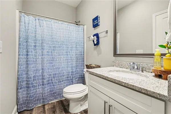 a bathroom with a granite countertop toilet sink and mirror