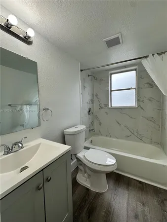 a bathroom with a sink a toilet and bathtub