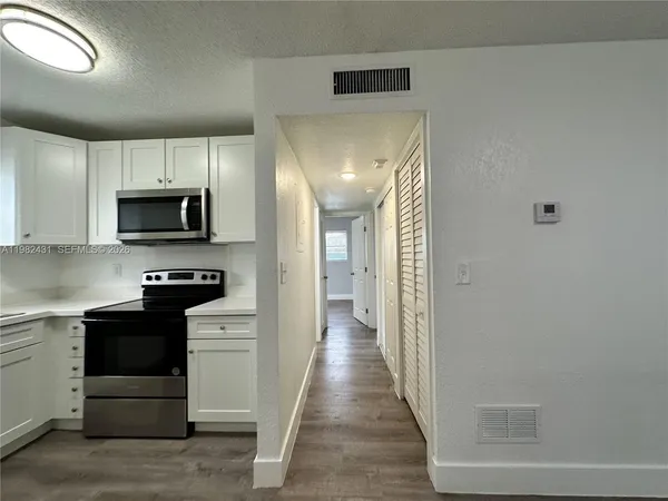 a kitchen with sink a microwave and cabinets