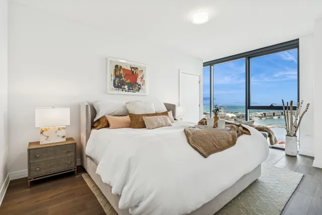 a bedroom with bed and a large window