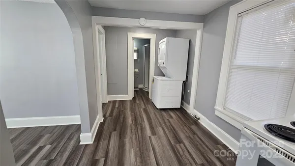 a view of a hallway with wooden floor and furniture