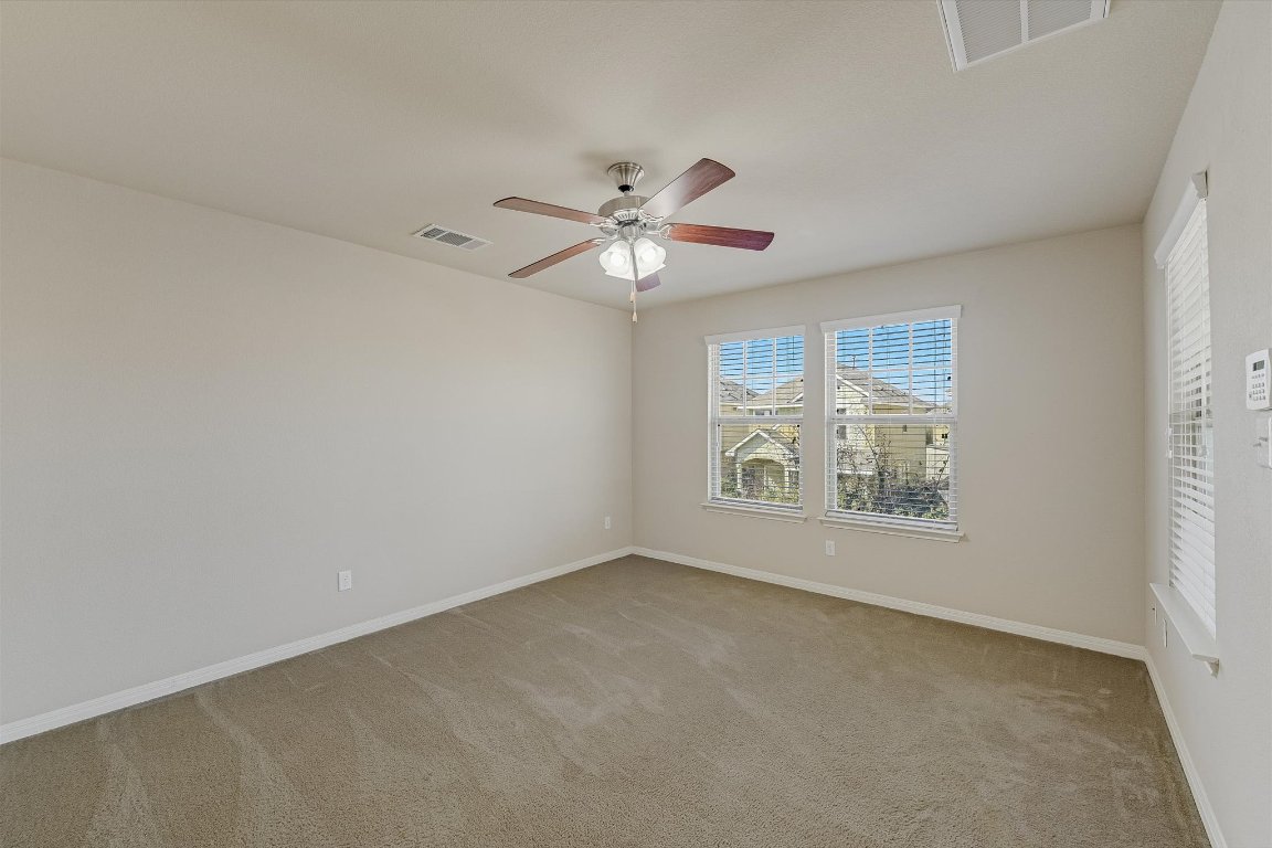 4609 Esper Lane, Unit 323 Austin, TX 78725 - Photo 11 of 20 an empty room with windows and fan