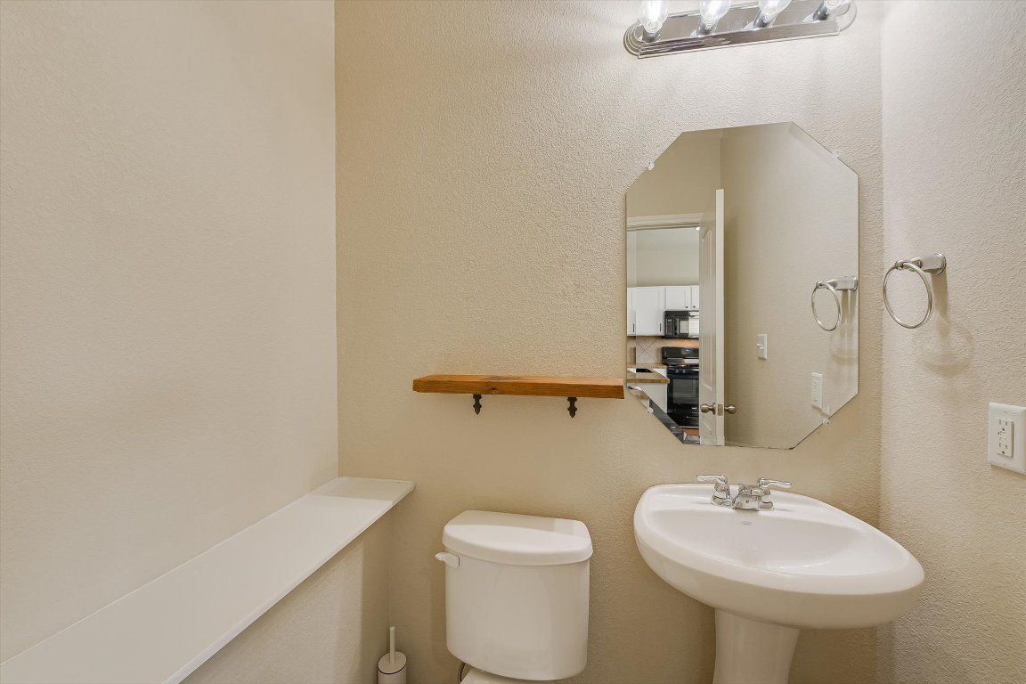 4609 Esper Lane, Unit 323 Austin, TX 78725 - Photo 17 of 20 a bathroom with a sink a toilet and mirror