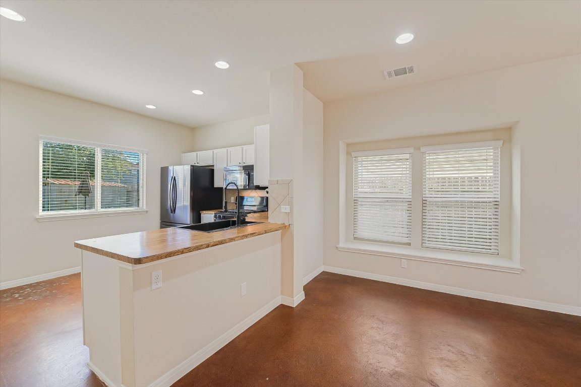 4609 Esper Lane, Unit 323 Austin, TX 78725 - Photo 6 of 20 a kitchen with stainless steel appliances granite countertop a sink stove and a refrigerator