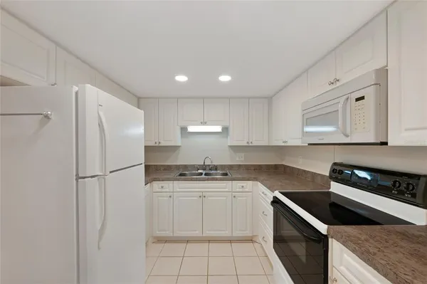 a kitchen with a sink a stove and cabinets