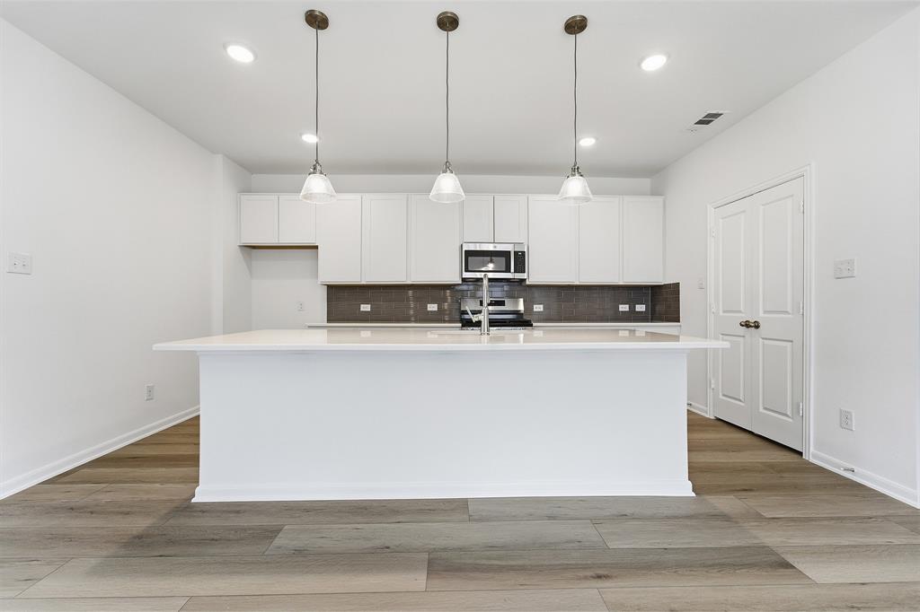 213 Charismatic Road Waxahachie, TX 75165 - Photo 11 of 21 a view of kitchen with stainless steel appliances granite countertop cabinets and wooden floor