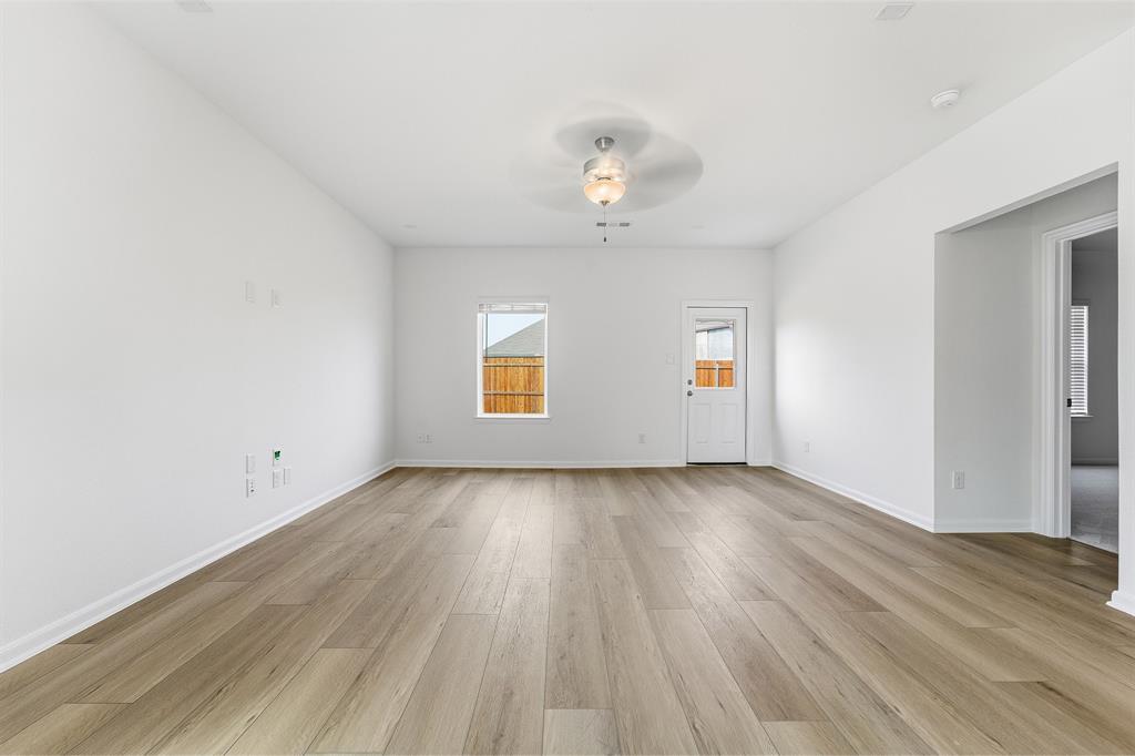 213 Charismatic Road Waxahachie, TX 75165 - Photo 12 of 21 an empty room with wooden floor and windows