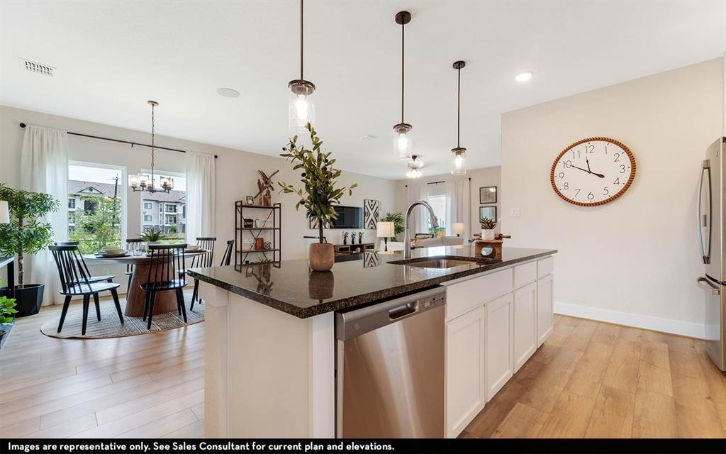 213 Charismatic Road Waxahachie, TX 75165 - Photo 13 of 25 a kitchen with stainless steel appliances granite countertop a kitchen island a stove and a view of living room