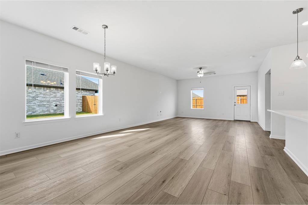 213 Charismatic Road Waxahachie, TX 75165 - Photo 13 of 21 a view of an empty room with window and wooden floor