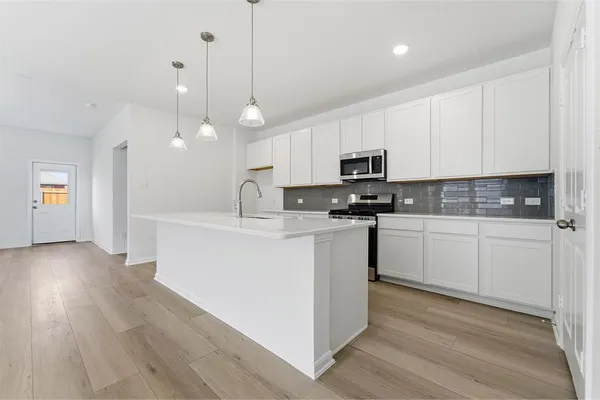 a kitchen with a sink a microwave and cabinets