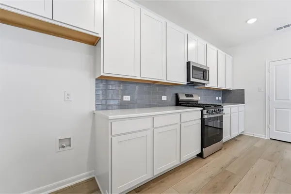 a kitchen with granite countertop white cabinets and white appliances