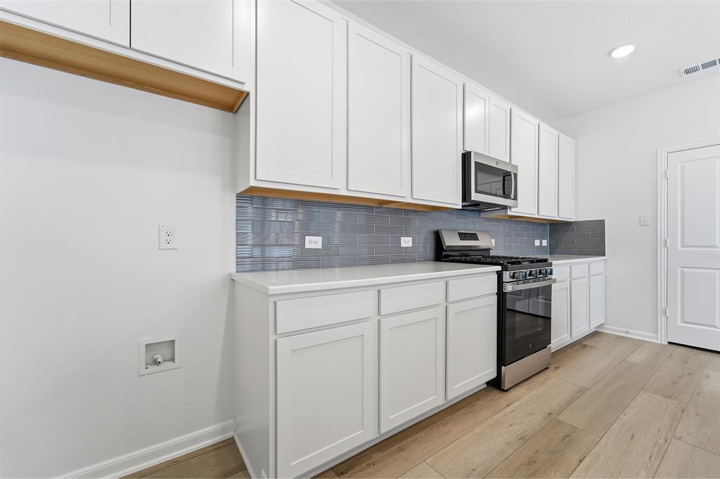 213 Charismatic Road Waxahachie, TX 75165 - Photo 8 of 21 a kitchen with granite countertop white cabinets and white appliances