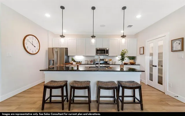 a kitchen with stainless steel appliances granite countertop a kitchen island a stove a table and chairs