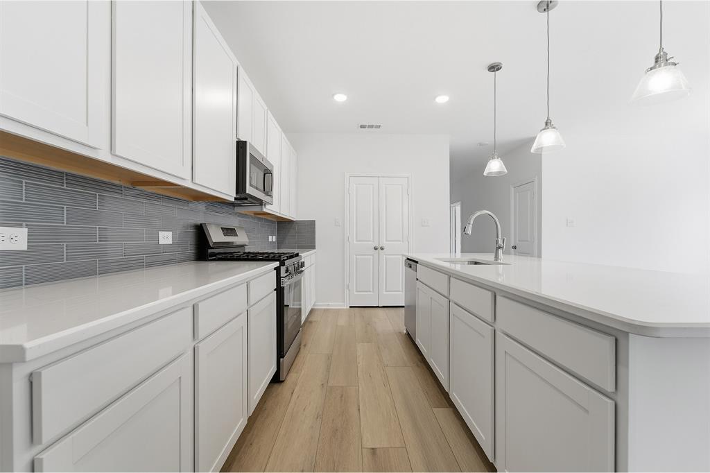 213 Charismatic Road Waxahachie, TX 75165 - Photo 10 of 21 a kitchen with white cabinets and sink