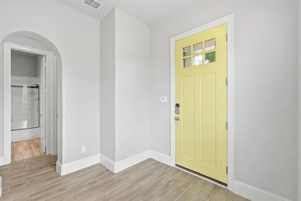 a kitchen with stainless steel appliances granite countertop a refrigerator a sink dishwasher a stove and white cabinets with wooden floor