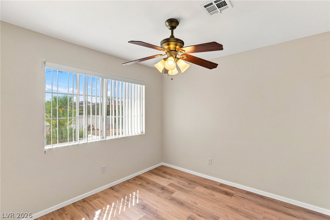 904 Shadowfax Road Henderson, NV 89015 - Photo 16 of 31 Rich wood plank flooring pairs beautifully with neutral walls and a wide window.