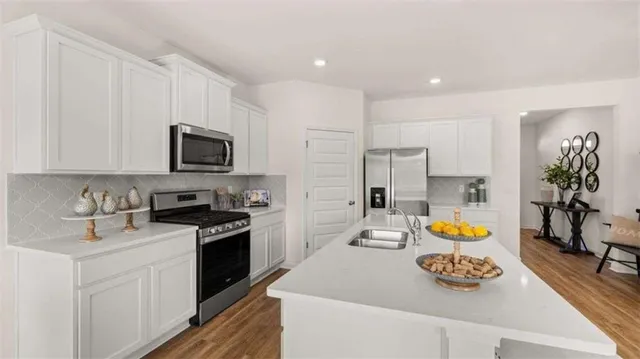 a kitchen with stainless steel appliances granite countertop a sink stove and refrigerator