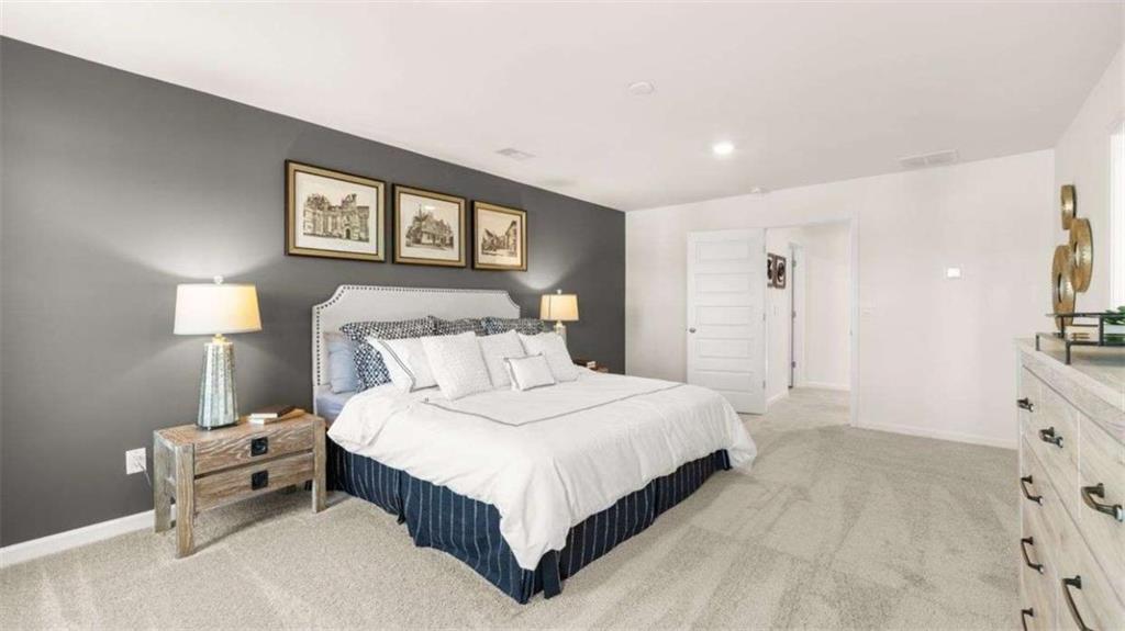 96 White Spruce Way Newnan, GA 30265 - Photo 25 of 43 a bedroom with a bed and a lamp on dresser