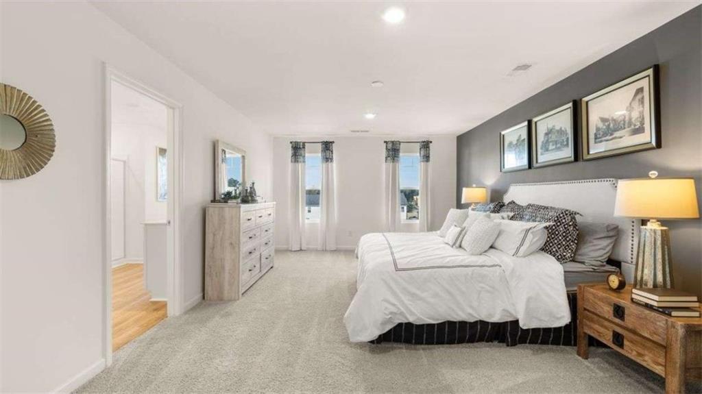 96 White Spruce Way Newnan, GA 30265 - Photo 27 of 43 a spacious bedroom with a bed a mirror and lamp