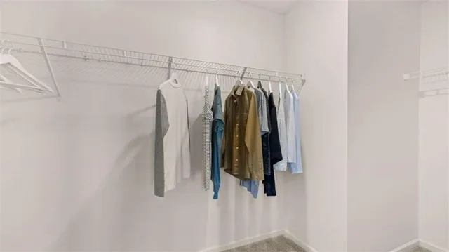a view of walk in closet with clothes