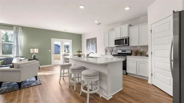 a kitchen with microwave a sink and chairs