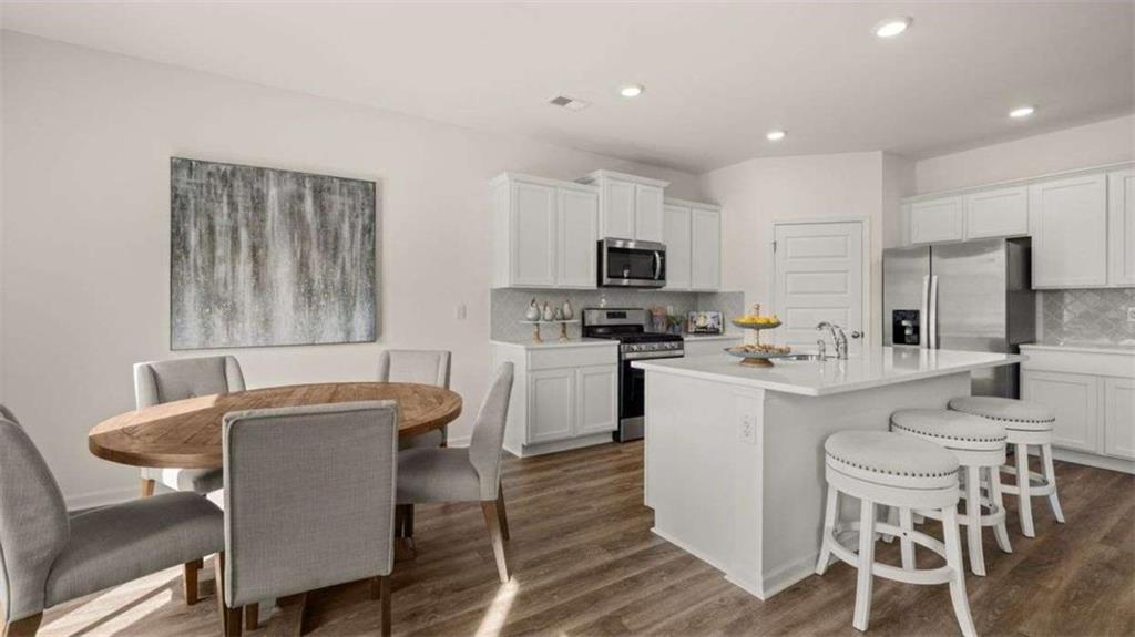 96 White Spruce Way Newnan, GA 30265 - Photo 10 of 43 a kitchen with white cabinets and chairs