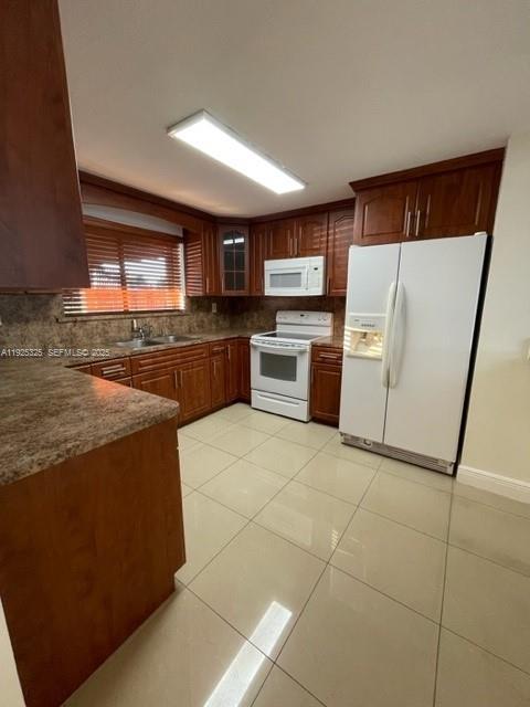 5631 West 28th Avenue, Unit 1 Hialeah, FL 33016 - Photo 4 of 18 a kitchen with a stove a refrigerator and a sink
