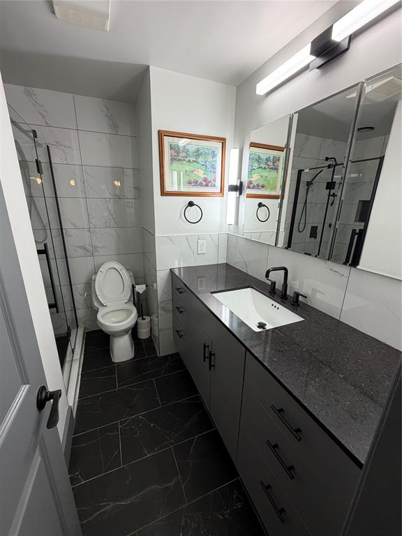 1605 South Houston Street Kaufman, TX 75142 - Photo 20 of 27 a spacious bathroom with a granite countertop sink toilet a mirror and a shower