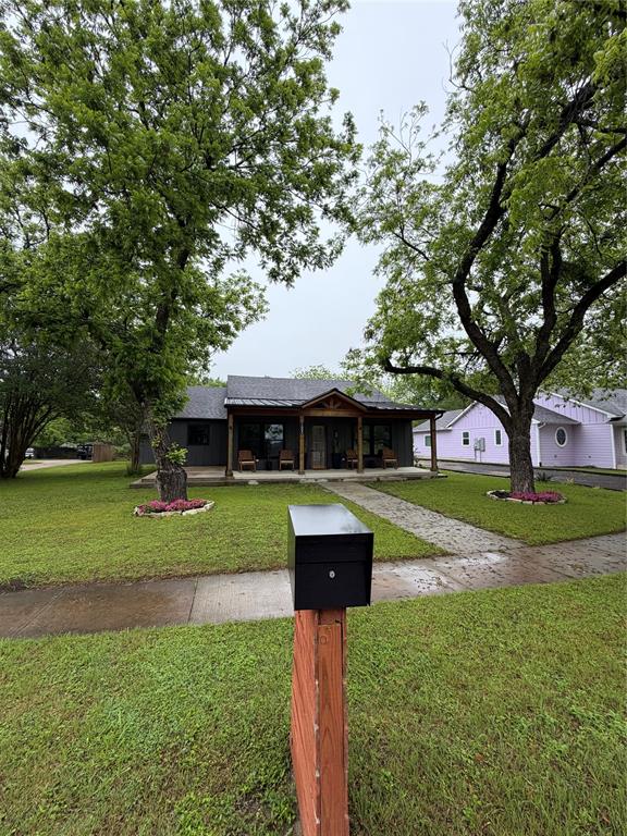1605 South Houston Street Kaufman, TX 75142 - Photo 2 of 27 a front view of a house with a yard